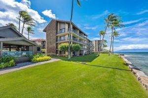 カハナにあるPapakea L402 · PK L402 Rare LUX Oceanfront Views, Pool, Paradiseの草とヤシの木のある家の外観