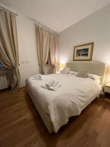 a bedroom with a white bed with two towels on it at Barbacan Boutique Hotel in Trieste