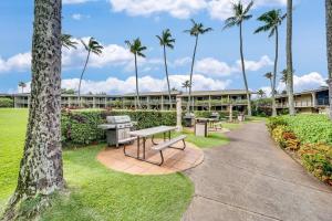 カハナにあるNapili Shores E240 · NS E240 Beautiful Condo w AC Close to Napilの建物前のベンチとヤシの木がある公園