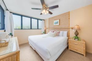 a bedroom with a white bed and a ceiling fan at Polynesian Shores 111 · PS 111 Updated Condo w Ocean Views Pool in Kahana +43 photos