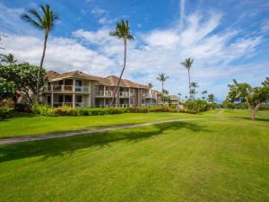 a house on a golf course with palm trees at Wailea Grand Champions 95 in Wailea