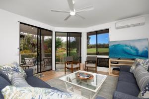 a living room with a blue couch and a tv at Wailea Grand Champions 95 in Wailea