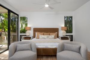 a bedroom with a bed and two chairs at Wailea Grand Champions 95 in Wailea +23 photos