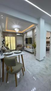 Апартаменты с дизайнерским ремонтом до моря 10минут с видом на горы и закат في شرم الشيخ: غرفة معيشة بها طاولة وكراسي