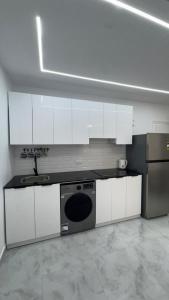 Апартаменты с дизайнерским ремонтом до моря 10минут с видом на горы и закат في شرم الشيخ: مطبخ مع خزائن بيضاء ومغسلة وغسالة أطباق +11 صورة