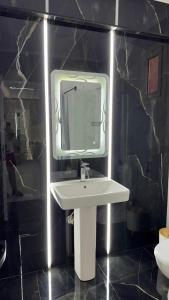 Апартаменты с дизайнерским ремонтом до моря 10минут с видом на горы и закат في شرم الشيخ: حمام مع حوض أبيض ومرآة