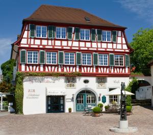 a house with a red and white building at Hotel Der Löwen in Hagnau