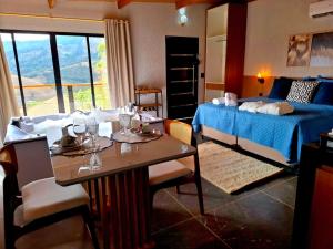 a bedroom with a bed and a table with glasses on it at Cabana Esmeralda Tesouros do Baú Segunda unidade in São Bento do Sapucaí
