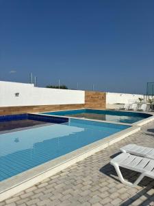 a swimming pool with a white chair next to a building at Casa Delta 187 in Parnaíba +15 photos