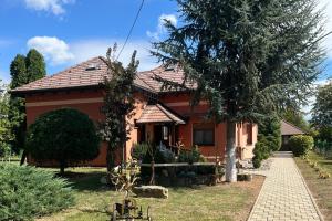 a red house with a tree in front of it at Family friendly house with a parking space Andrijasevci, Slavonija - 24939 in Rokovci
