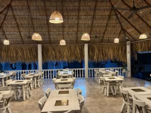 a restaurant with white tables and chairs and chandeliers at Dorado hotel boutique in Tocaima