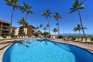 カハナにあるPapakea A301 · PK A301 BeachFront Corner Condo w Ocean Views Pooのヤシの木が茂るリゾートのスイミングプール