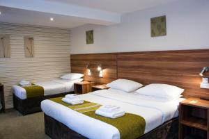 a hotel room with two beds and two lamps at Helix Hotel in Grangemouth