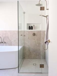 a bathroom with a glass shower with a tub and a sink at Luxury 3-Bed Family Retreat Office Kayaks & Yard in Marsden