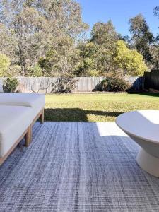 a patio with a white couch and a table at Luxury 3-Bed Family Retreat Office Kayaks & Yard in Marsden