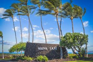 un panneau devant les palmiers, dans l'établissement Palm Villas stylish luxury condo with Mauna Lani Beach Club Access, à Waikoloa