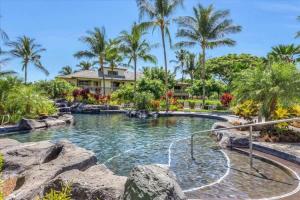 une piscine dans un complexe hôtelier avec des palmiers dans l'établissement Ground Floor Condo with Private Mauna Lani Beach Club Access- Perfect for families, à Waikoloa