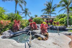 un jardin avec une piscine et une cascade dans l'établissement Ground Floor Condo with Private Mauna Lani Beach Club Access- Perfect for families, à Waikoloa