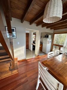 a dining room with a wooden table and a kitchen at Cabañas ROCA DEL LAGO, en Villa Pehuenia in Aluminé +21 photos