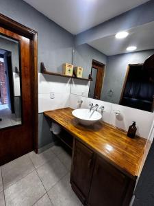 a bathroom with a sink and a wooden counter at Cabañas ROCA DEL LAGO, en Villa Pehuenia in Aluminé