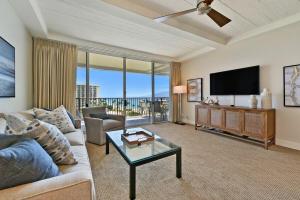 a living room with a couch and a flat screen tv at Whaler 859 BeachFront Luxury Condo w Ocean Views in Lahaina