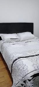 un letto con piumone e cuscini in bianco e nero di Moderno apartamento frente a viva mall a Tunja