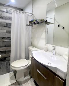 a bathroom with a sink and a toilet and a mirror at Tapia Haus 103 - San Juan, Beach Vibes Walking Distance in San Juan +18 photos