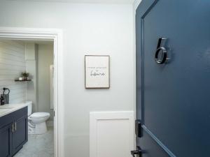 a bathroom with a toilet and a blue door at Jennifer's Modern & Comfy Broadway Retreat in Providence