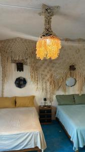 une chambre avec deux lits et un lustre dans l'établissement Casa Hijos del Cocho Bacalar, à Bacalar