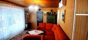 バラトンベレーニにあるHoliday home Balatonbereny - Balaton 18150のオレンジ色のソファとテーブルのあるリビングルーム