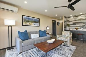 una sala de estar con un sofá y una mesa en Nani Kai Hale 605 · NKH 605 Remodeled BeachFront w Pool AC Sandy, en Kihei