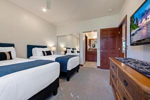 a hotel room with two beds and a flat screen tv at Wailea Grand Champions 185 in Wailea +23 photos
