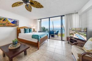 a bedroom with a bed and a living room with a balcony at Valley Isle 206 · VI 206 OceanFront Studio w Pool in Kahana +171 photos
