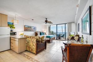 a living room with a couch and a kitchen with a view at Valley Isle 206 · VI 206 OceanFront Studio w Pool in Kahana