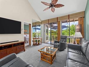 a living room with a flat screen tv and a couch at Wailea Grand Champions 140 in Wailea