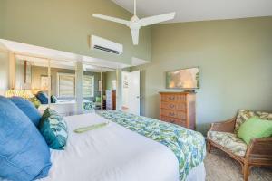 a bedroom with a large white bed and a chair at Koa Resort 3J · KOA 3J Remodeled 3BD w AC Pool Near Sandy Beach in Kihei +43 photos