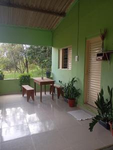 a patio with a table and benches in a green building at Casa Baunilha in Cavalcante