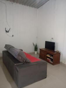 a bedroom with a couch and a tv and a table at Casa Baunilha in Cavalcante