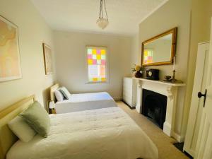 a bedroom with two beds and a fireplace at Olde' Haven - Federation Charm close to CBD in Bathurst
