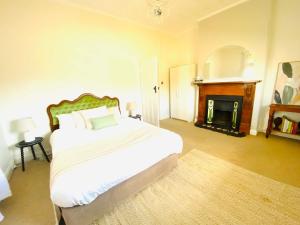 a bedroom with a large bed and a fireplace at Olde' Haven - Federation Charm close to CBD in Bathurst