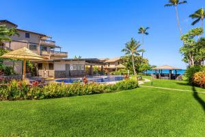 a yard with a swimming pool and a resort at Oceanfront & ac! ks d9 - Sullivan Properties in Kahana