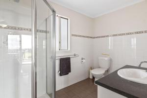 a bathroom with a toilet and a sink and a shower at Baywatch - 8 James Drive, Carrickalinga in Carrickalinga +17 photos