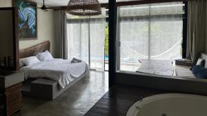 a bedroom with a bed and a window and a tub at Cerro Tusa Springs in Venecia