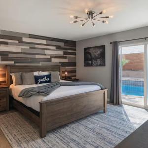 ein Schlafzimmer mit einem Bett und einer Akzentwand aus Holz in der Unterkunft Fresh & Fun! Vegas 4BR w Heated Pool, Dog Friendly in Las Vegas