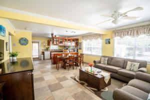 a living room with a couch and a table at Sea Beauty - Charming Cottage with Pool and Private Beach Lot in North Side