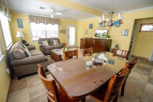 a dining room and living room with a table and chairs at Sea Beauty - Charming Cottage with Pool and Private Beach Lot in North Side