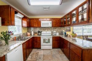 a kitchen with wooden cabinets and white appliances at Sea Beauty - Charming Cottage with Pool and Private Beach Lot in North Side