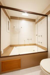 a bathroom with a tub and a toilet at Duplex Cobertura - Resort no Coração de Gramado in Gramado