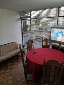 uma sala de estar com uma mesa vermelha e uma televisão em 3D2B apartment in the heart of Viña em Viña del Mar