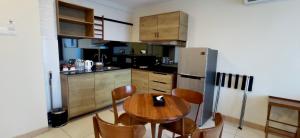 a kitchen with a wooden table and a refrigerator at Timurbay Residences in Kuantan